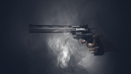 Obraz premium Hand holding a revolver in a dark, smoky atmosphere. The image evokes a sense of suspense and danger. Concept of Gun Violence