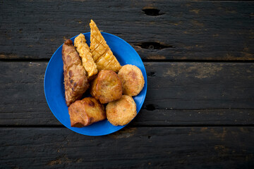 Various traditional fried food, Gorengan from Indonesia, on a blue plastic plate