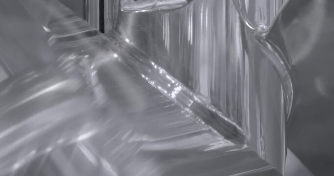 The chrome-plated steel impeller rotates, producing shifting reflections across its polished surfaces. Close up shot, abstract metal background.