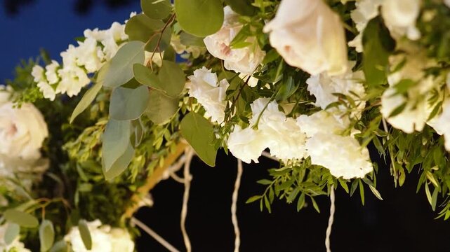 Beautiful white roses and eustoma flowers with petals and a romantic atmosphere. Outdoor wedding ceremony for the bride and groom. Decor and floristry.