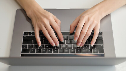 Top view of woman's hands typing on laptop keyboard, representing work, AI prompt, research, social networks, and remote education in a modern workspace.