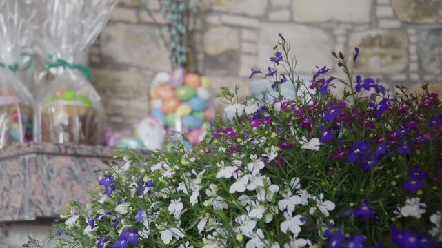White purple lobelia with pastel eggs, stone wall backdrop with glass jars of colorful candy, bustling market stall mood, vendor arranging bouquet, soft