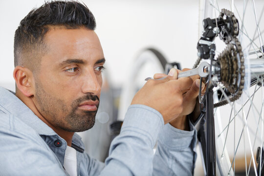 a man repairing a bicycle wheel - Powered by Adobe