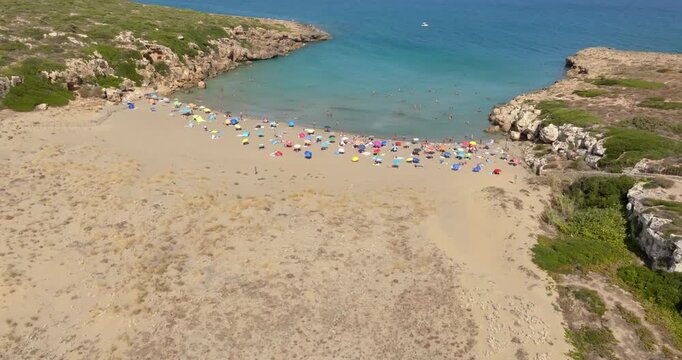 Aerial view of Cala Mosche (or Calamosche) beach, a beautiful sandy beach within the Vendicari Nature Reserve, near Noto, Sicily, Italy. It's famous for its crystal clear and blue waters. Sunny day.