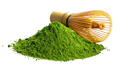 A vibrant green powder with a bamboo whisk, all on a stark black background