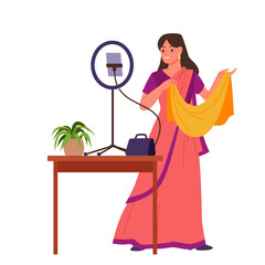 Indian woman blogger in red saree standing at ring light and smartphone on stand to make content for fashion blog. Young beautiful female character in traditional dress cartoon vector illustration