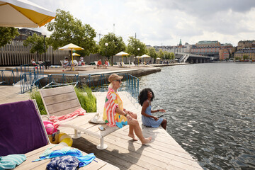 High angle view of female friends enjoying leisure time at riverbank