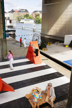 High angle view of man doing stunt on structure while mature couple spending leisure time