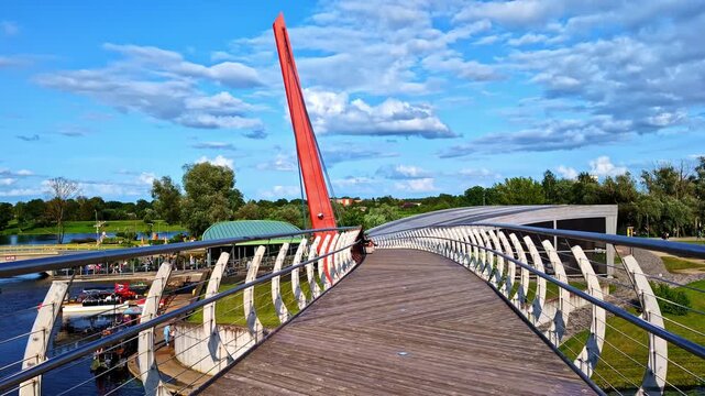 Wide view on empty wooden pedestrian bridge (Mītava bridge) in Jelgava, Latvia on sunny summer evening