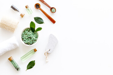 Naklejka na ściany i meble Spa pedicure accessories and organic cosmetics products - tea tree essential oil and sea salt near green leaves top view