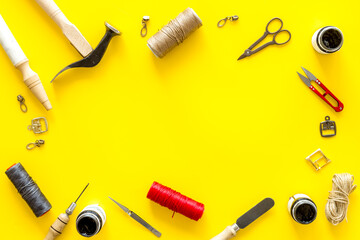 Frame flat lay of leather craftsman or shoemaker tools and equipment, top view