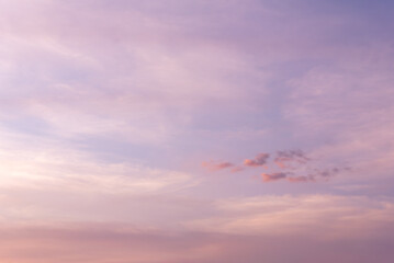 Beautiful pastel sky with soft sunset clouds in shades of pink, purple, and orange. Tranquil scene perfect for abstract background, copy space, and designs symbolizing calm and peaceful mood.