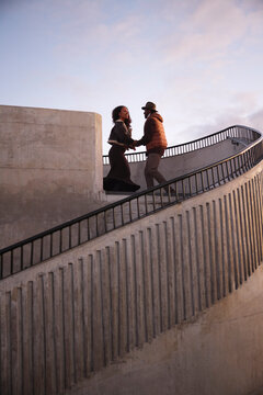 Low angle view of friends dancing on steps against sky