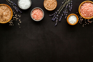 Beauty spa therapy cosmetics and wellness flat lay - sea salt in many bowls with flowers, top view