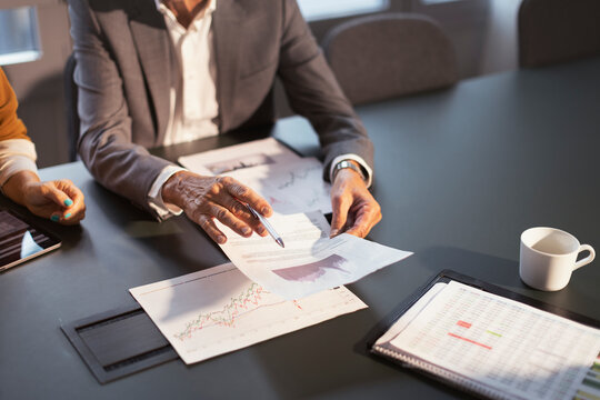 High angle view of businessman holding progress report in hand at office meeting