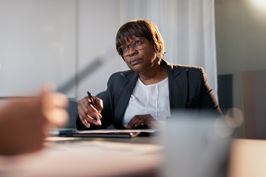 Focused mature female corporate professional in meeting with colleague at office