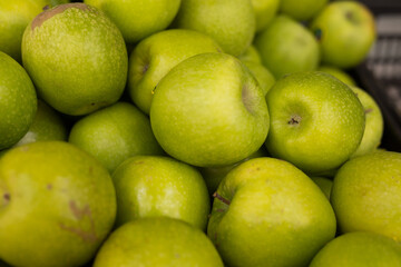 appetizing green apples on counter in market