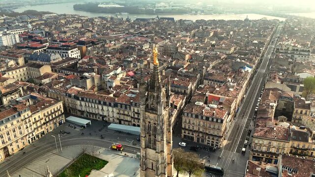 Aerial detail of golden Virgin Mary statue Pey Berland Tower with tram tracks and river skyline