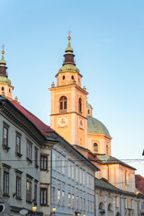 Twin towers of St. Nicholas Cathedral glowing in warm sunset light above the old town of Ljubljana, Slovenia