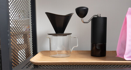 Coffee dripper, grinder and glass server on bamboo tray. Alternative coffee brewing set  in banner format