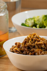 healthy home cooked meal with broccoli, beef, and pickled vegetables in white bowls