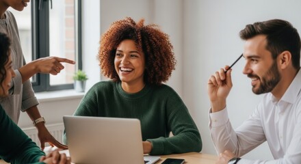 Diverse, happy business people collaborate around a laptop in a bright office, showcasing team success, communication, and modern workplace environment.