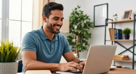 Smiling handsome young man working on his laptop at a wooden table in a well-lit home setting, emphasizing a modern, cheerful, and productive work-from-home life.