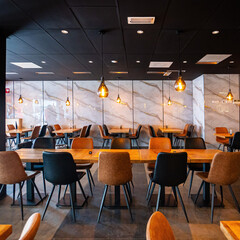 Cozy and modern coffee shop interior with wooden furniture, warm lighting, and large windows overlooking the street, creating an inviting atmosphere