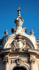 Fototapeta premium Ornate stone architectural detail with decorative carvings against a bright blue sky.