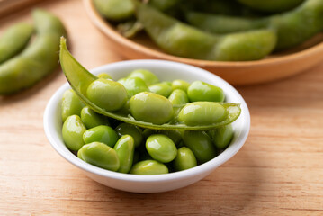 Boiled Edamame beans (Japanese soybeans) in a bowl on wooden background