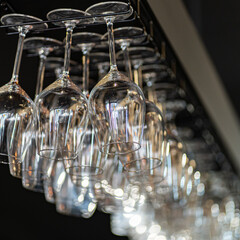 Row of the upturned crystal wine glasses on bar table