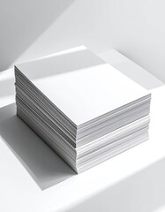 A tall stack of blank white paper sits on a white surface under bright, directional light.