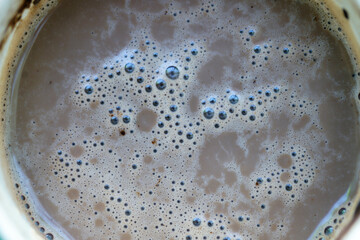 Close-Up View of Creamy Coffee Foam in a Cup with Bubbles