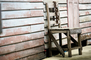 Abandoned Wooden Chair with Chain Against Weathered Wall Background