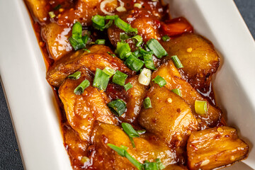Closeup of spicy glazed potatoes with onions