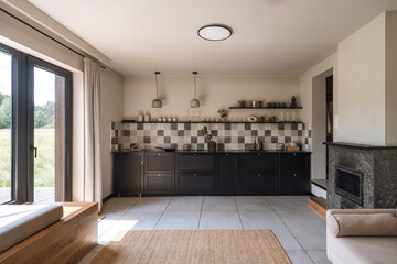 Modern kitchen design with black accents and natural light in a spacious apartment