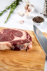 Raw ribeye steak with herbs and spices