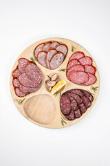 Assorted sliced deli meats on round wooden board