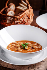 Bean stew with bread basket in rustic setting