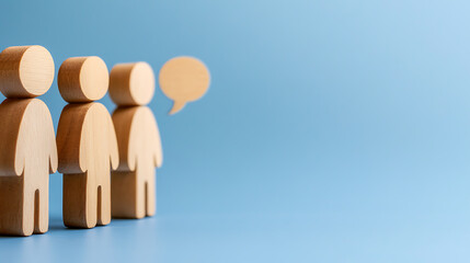 Conceptual representation of teamwork and communication with wooden figures on a blue background, symbolizing connection, cooperation, and the exchange of ideas.
