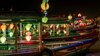 Colorfully decorated boats with lanterns waiting along the riverbank in Hoi An, Vietnam at night. © Ben D.