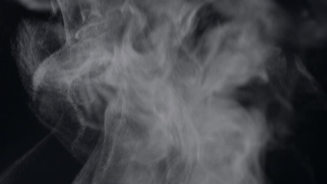 White natural rising steam from food or hot drink isolated on a black background.