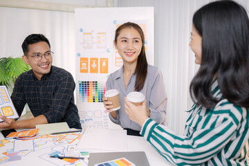Obraz premium UX/UI designers presenting their final design project to the team, showcasing app interface screens and explaining user experience strategies in a professional creative office environment.