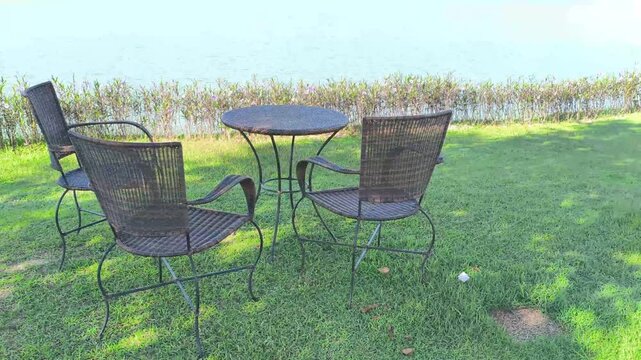 wicker rattan chair table for resting on terrace at waterside of pond lake