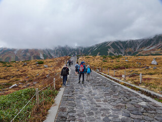 Obraz premium 秋の観光名所立山黒部アルペンルートの室堂山頂で歩く観光客の姿と山の風景