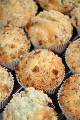Freshly baked muffins with crumble on top. Top view homemade treats in paper cup, vertical photo.