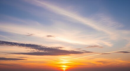 Fototapeta premium Beautiful sunset sky with soft clouds in warm orange, yellow, and blue tones. Perfect for backgrounds, meditation apps, travel posts, or wellness content. Peaceful atmosphere.