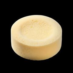 Round piece of pale yellow cheese with small holes