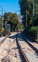 Two railway tracks in the middle of the city. Repair work with an excavator on the railway tracks. Excavator on the railway track