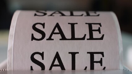 Printing the word "SALE" on white paper, close-up. Sale announcement - Powered by Adobe